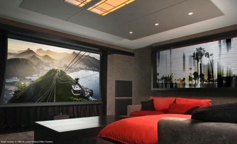 high-end home theater with plush seating, wooden coffee table, and large projection screen image