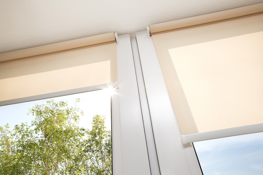 Image is of a pair of motorized blinds covering the windows in a home.